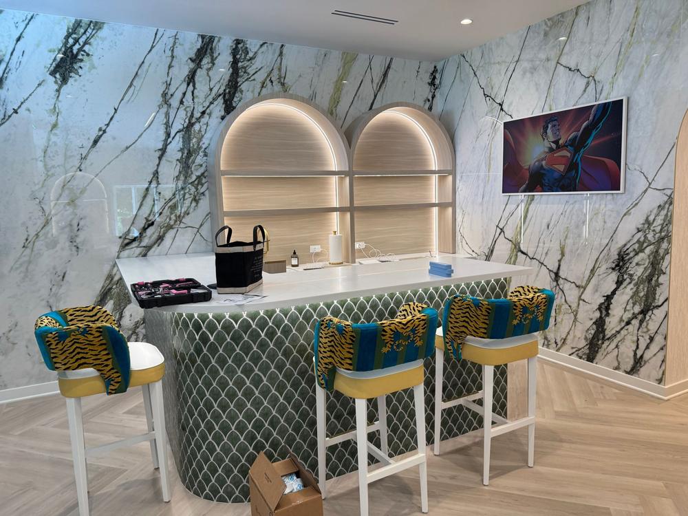Lounge area with a marble feature wall, arched shelving and bar stools