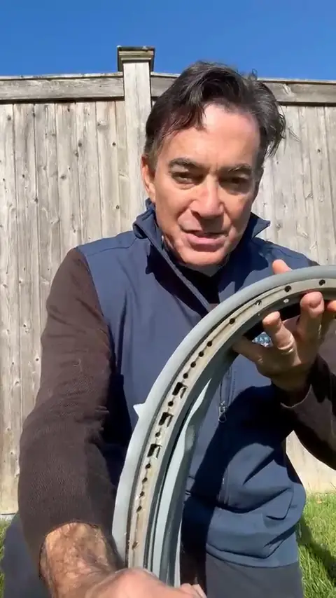 Rich from Way Beyond Cleaning holding a gray front-load washer door gasket with dark mold staining along its inner edge